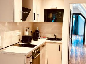 a kitchen with white cabinets and a sink at Hotel Schneider Hof - Self-Check-In by RG Living in Bad Salzuflen +23 photos
