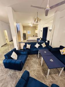 a living room with blue couches and a kitchen at Happiness Guest House in Luxor
