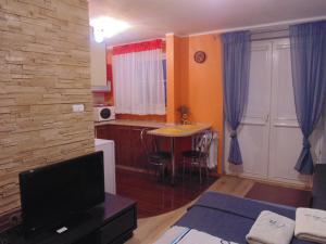 a living room with a kitchen and a table with a tv at Nocleg u Mario in Uniejow