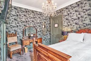 a bedroom with a bed and a mirror and a chair at The Lawrence in Derry Londonderry