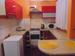 a small kitchen with red cabinets and a sink at Nocleg u Mario in Uniejow