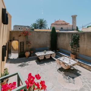 a patio with a table and chairs and flowers at Zacosta Villa - a Heritage Hotel in Rhodes Town +111 photos