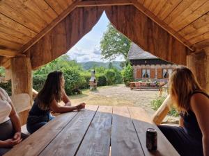 a group of women sitting at a picnic table in front of a barn at Jagdhütte Breidelsley in Nideggen +10 photos