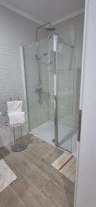 a glass shower with a chair in a bathroom at Rooms Lanterna in Metajna