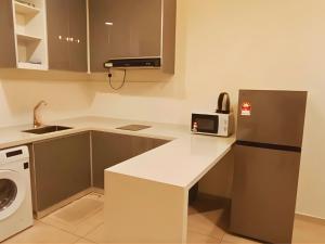 a small kitchen with a refrigerator and a microwave at ImpianKU MetaStay KL in Seri Kembangan