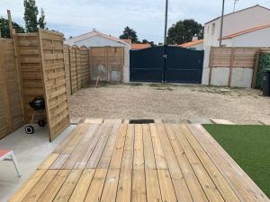 a backyard with a wooden deck and a fence at Marieno in Barbâtre