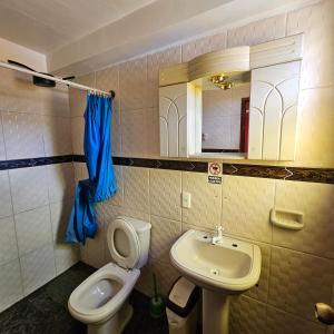 a bathroom with a toilet and a sink at Bolivian Heights Hostel in La Paz