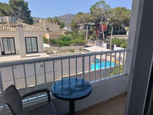 a balcony with a table and chairs and a swimming pool at Hostal Bélgica in Palmanova
