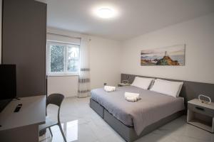 a bedroom with a bed and a desk and a television at Loft Giuliana in San Michele allʼAdige