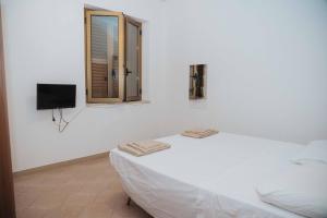 a white room with a bed and a window at Tonnara Vista Mare in Palmi +1 photo