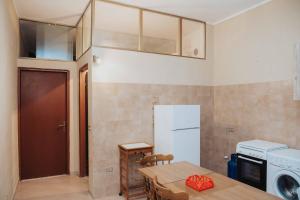 a small kitchen with a table and a refrigerator at Tonnara Vista Mare in Palmi