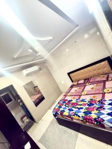 a bedroom with a bed with colorful quilts at Santhosh hotel in Khammam
