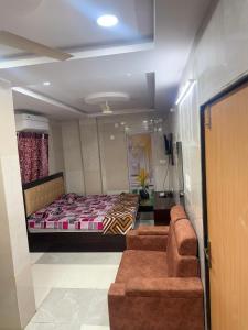 a bedroom with a bed and a couch in a room at Santhosh hotel in Khammam