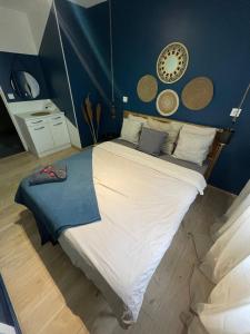 a bedroom with a large bed with blue walls at Oasis in Agen