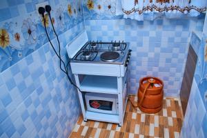 a kitchen with a stove in a blue tiled room at Kajole Homestay in Kakamega