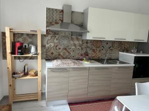 a kitchen with white cabinets and a sink at Casa Nonna Etna in Linguaglossa +3 photos