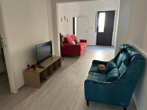 a living room with a blue couch and a television at Casa Nonna Etna in Linguaglossa