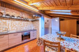 a kitchen with a table and a sink and a refrigerator at Tizzi Home in Alleghe