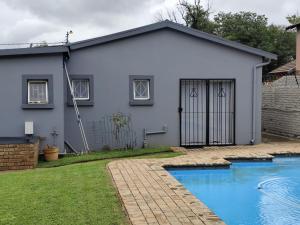 a white house with a swimming pool in front of it at 899 On Burlington in Pretoria