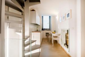a small kitchen with a spiral staircase in a small apartment at Dimora Delle Stelle - Design & Heritage in Bari
