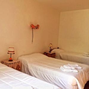 a hotel room with two beds with towels on them at Munay Posada in Los Cocos