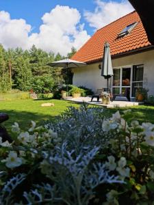 a house with an umbrella and a yard with flowers at Agroturystyka TWÓJ KĄCIK in Kurzętnik