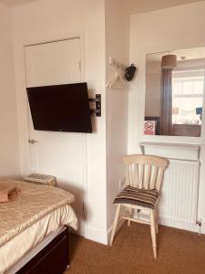 a bedroom with a bed and a television on a wall at The Haven in Holyhead