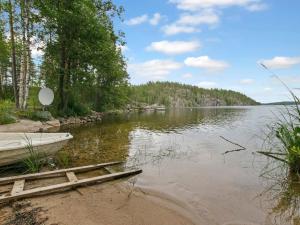 a boat on the shore of a lake at Holiday Home Ulappa by Interhome in Hurissalo