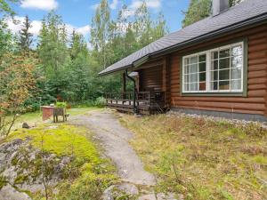 a log cabin with a pathway next to a house at Holiday Home Ulappa by Interhome in Hurissalo