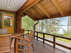 a porch of a cabin with a table and chairs at Holiday Home Ulappa by Interhome in Hurissalo