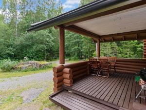 a wooden deck with a table and chairs on it at Holiday Home Ulappa by Interhome in Hurissalo +22 photos