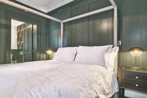 a bedroom with a white bed and a mirror at The Lawrence in Derry Londonderry