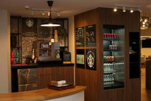 a bar in a restaurant with a counter and a drink at Holiday Inn Basingstoke by IHG in Basingstoke