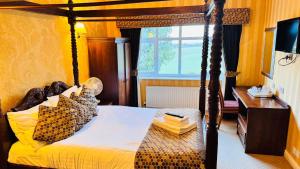 a bedroom with a canopy bed and a desk at Buckatree Hall Hotel in Telford +46 photos