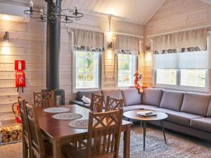 a living room with a couch and a table at Holiday Home Pikkuhukka by Interhome in Hyrynsalmi +19 photos