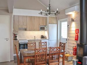 a kitchen with a table and chairs and a refrigerator at Holiday Home Pikkuhukka by Interhome in Hyrynsalmi