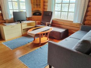 a living room with a couch and a tv at Holiday Home Heinäsorsa by Interhome in Rutalahti