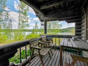 a porch of a cabin with two chairs and a table at Holiday Home Heinäsorsa by Interhome in Rutalahti