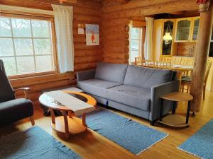 a living room with a couch and a table at Holiday Home Heinäsorsa by Interhome in Rutalahti