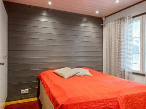 a bedroom with a red bed and a gray wall at Holiday Home Pulkka 2 by Interhome in Salla
