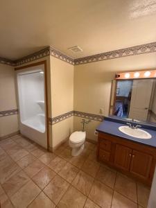 a bathroom with a toilet and a sink and a mirror at Angelina Motel in Lufkin +2 photos
