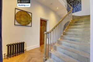 a staircase in a house with a picture on the wall at Large 6BDR House By Homebird Property Management Short Lets & Serviced Accommodation Leeds With Secured Parking & Garden Area in Leeds