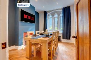 a dining room with a wooden table and chairs at Large 6BDR House By Homebird Property Management Short Lets & Serviced Accommodation Leeds With Secured Parking & Garden Area in Leeds