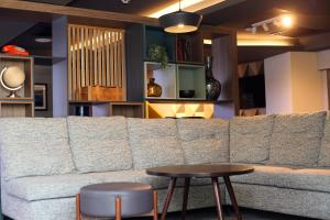 a living room with a large couch and a table at Holiday Inn Basingstoke by IHG in Basingstoke +73 photos