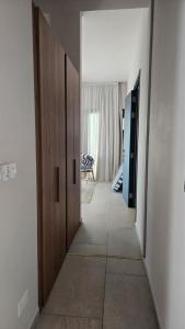 a hallway with two wooden doors and a room at 1BR Serviced Apt with Pool & Premium Amenities in Oroklini