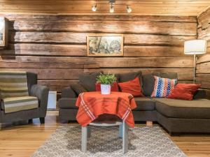 a living room with a couch and a table at Holiday Home Metsäpirtti by Interhome in Vaskivesi