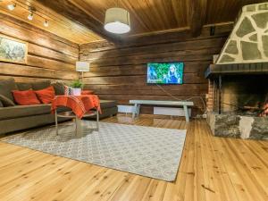 a living room with a couch and a fireplace at Holiday Home Metsäpirtti by Interhome in Vaskivesi