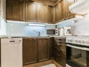 a kitchen with wooden cabinets and a white dishwasher at Holiday Home Metsäpirtti by Interhome in Vaskivesi +31 photos