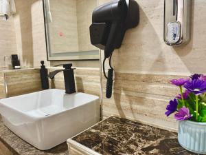 a bathroom with a sink and a phone on the wall at Annavilla7 Lilongwe hotel in Lilongwe