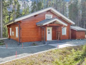 a wooden cabin with a white door in the woods at Holiday Home Villa utu by Interhome in Kolinkylä